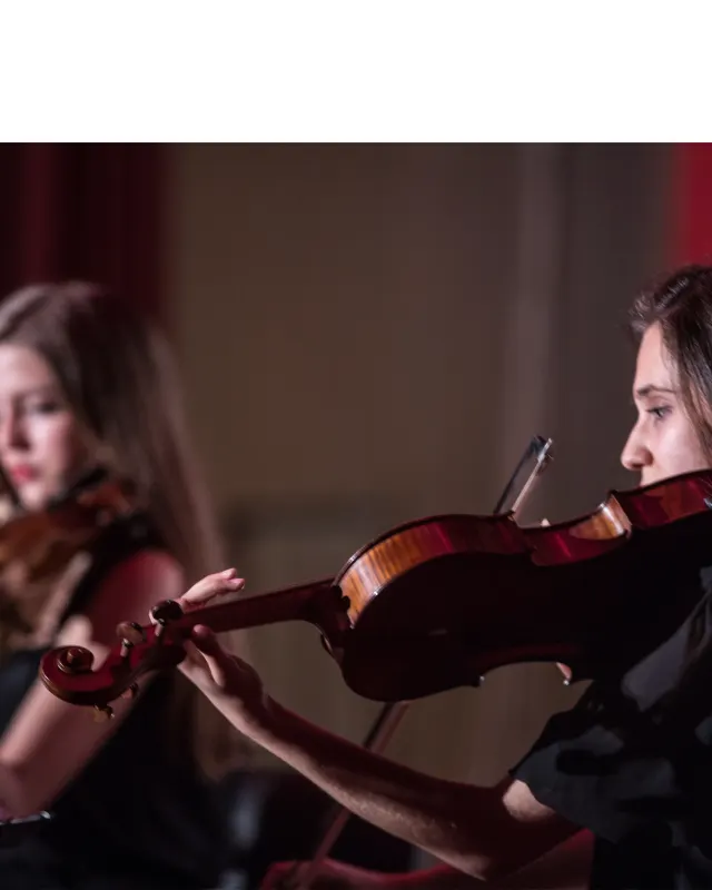 Konserde keman çalan öğrenciler